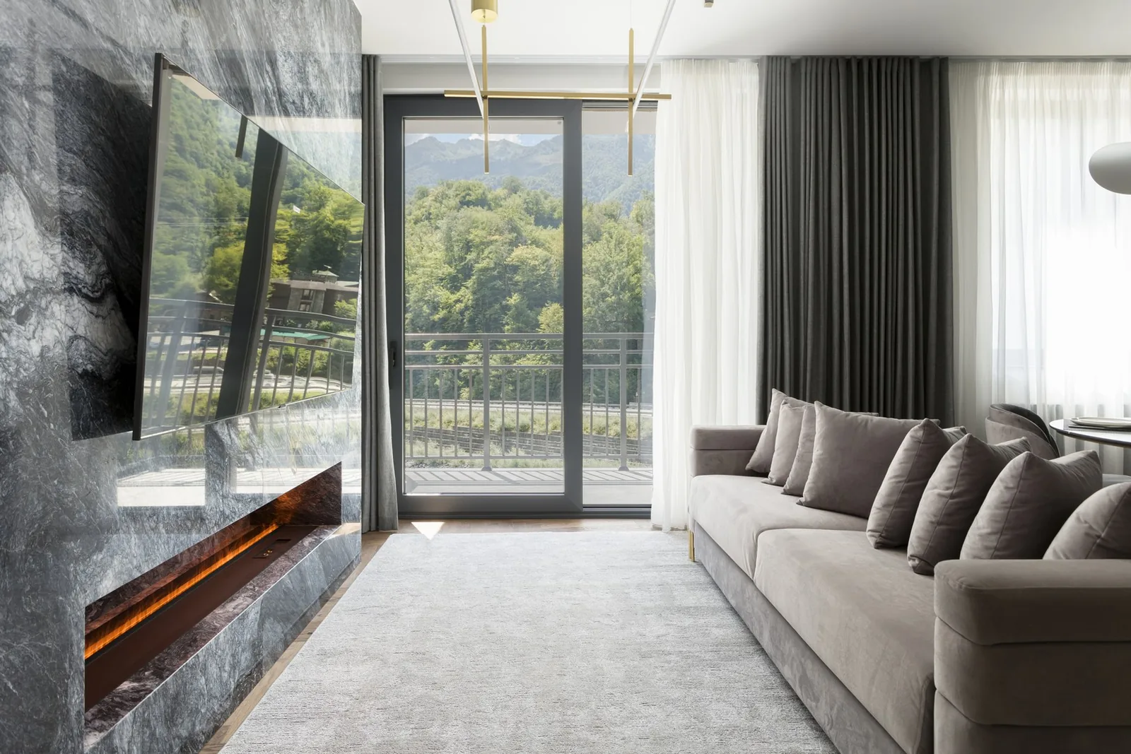 LeePrime Residences — гостиная апартамента с камином и панорамным видом на горы